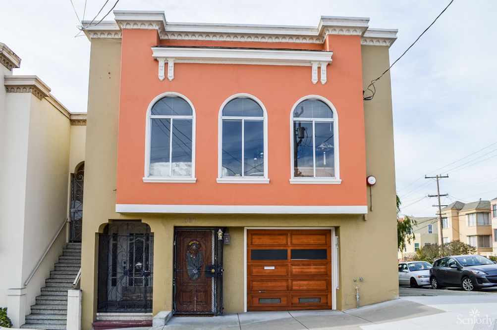 A two-story house with an orange facade and arched windows.