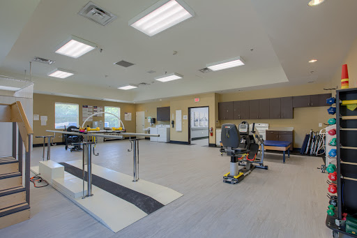 A spacious rehabilitation therapy room equipped with exercise equipment, designed for patient recovery and physical therapy.