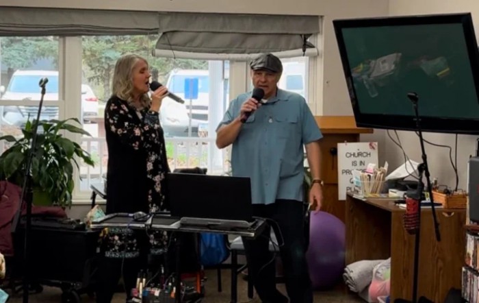 Two people singing karaoke indoors with microphones.