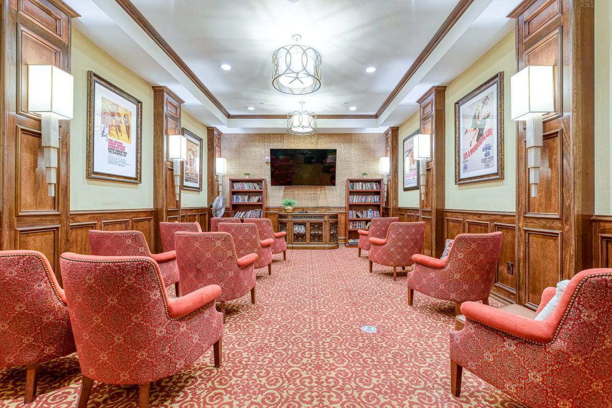 A cozy interior seating area with red chairs, a television, and warm lighting.