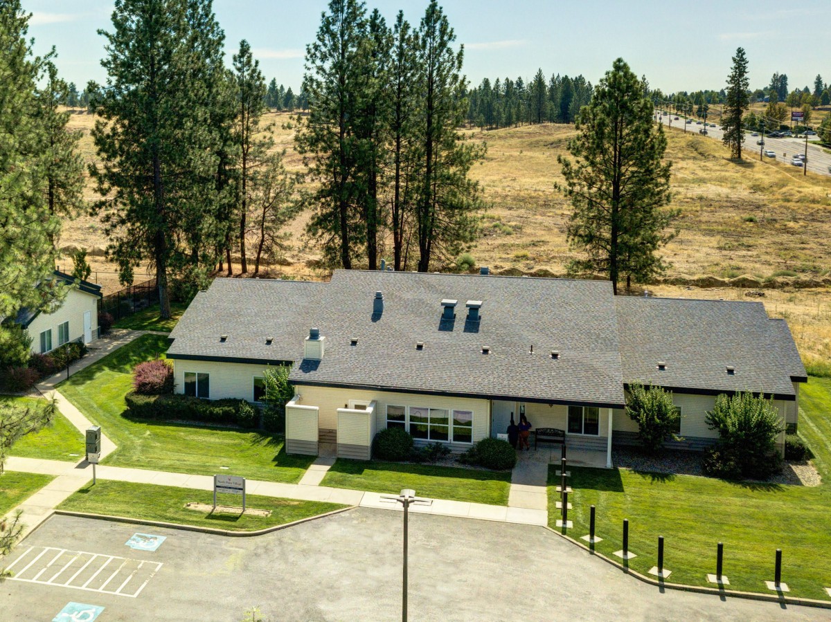 Aerial view of a single-story building surrounded by trees and open landscape.