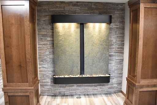 A stylish indoor water feature with ambient lighting, set against a textured stone wall for a modern touch.
