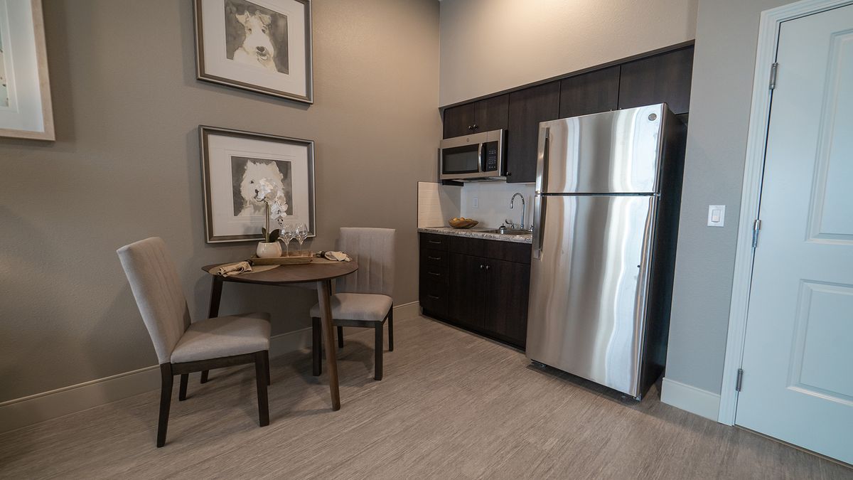 A modern apartment kitchen with a small dining area.