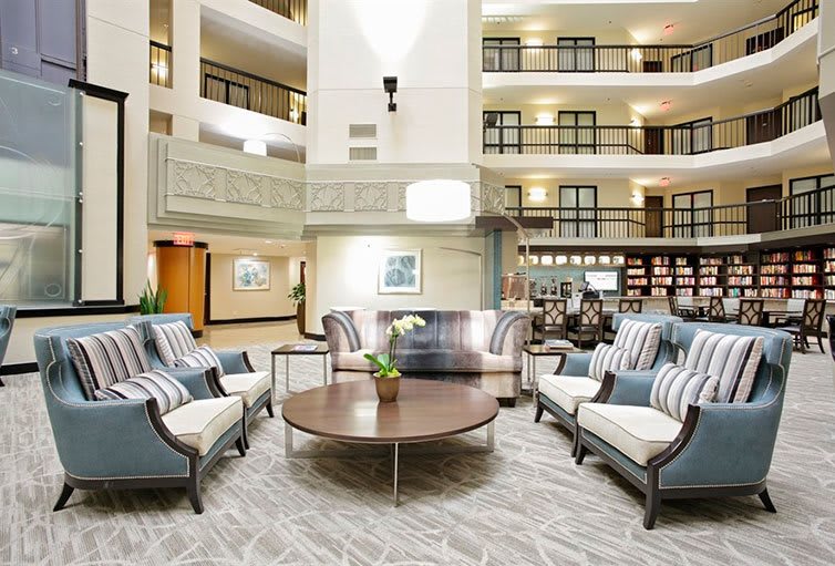 A modern hotel lobby with a spacious seating area featuring elegant furniture.