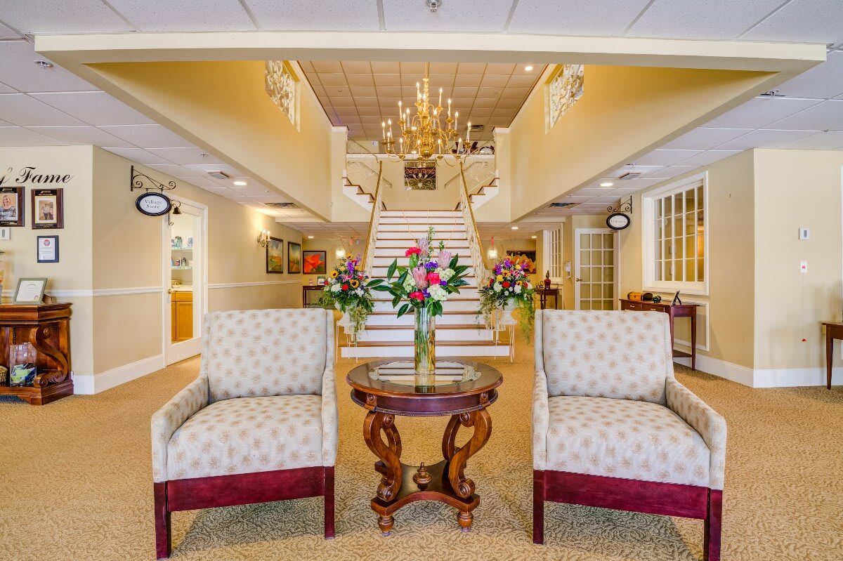 A luxurious lobby with a grand staircase and elegant seating area.