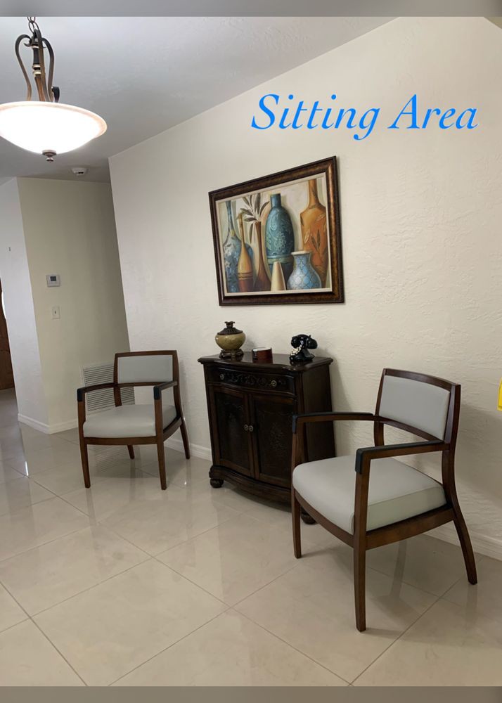 A cozy sitting area with two chairs, a side table, and a decorative painting on the wall.