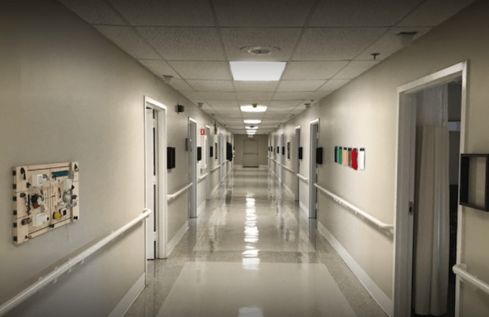 An empty hospital corridor with doors on both sides.