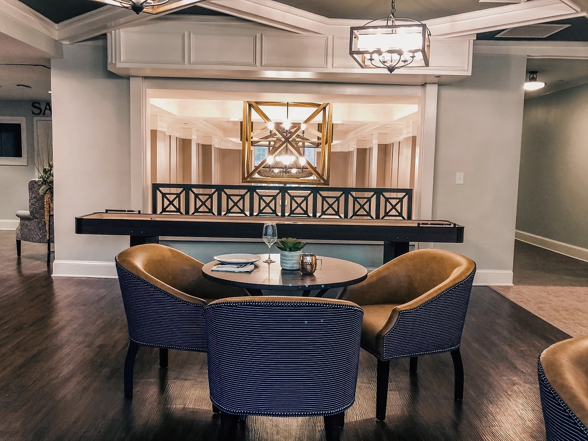 A modern interior dining area featuring stylish chairs and a decorative table with artwork in the background.