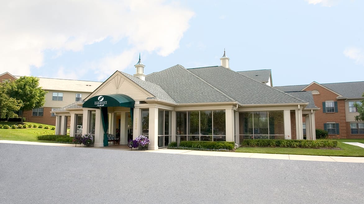 A building with a green awning at the entrance and a clear sky backdrop.