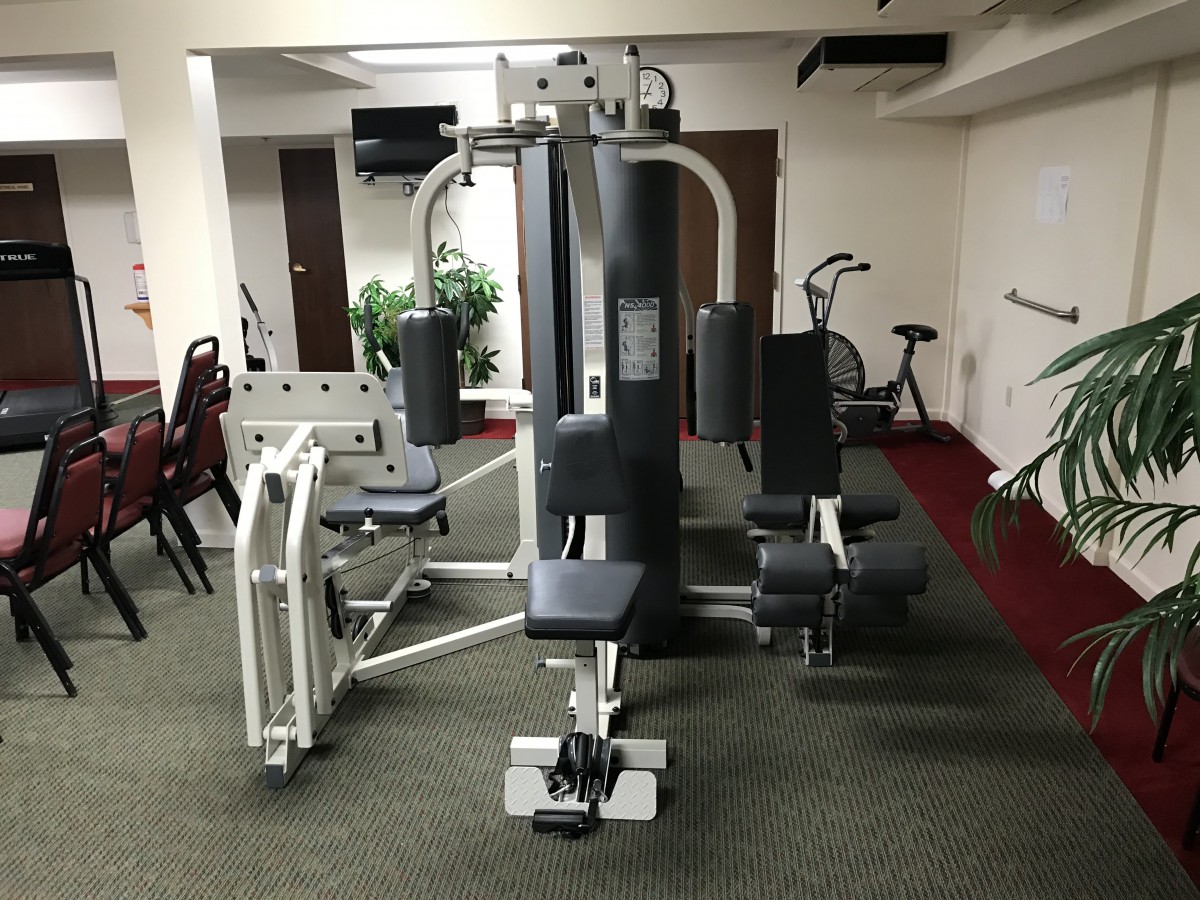 A gym with various fitness equipment, including exercise machines and bikes.