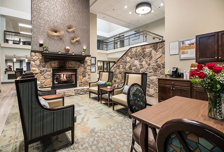 A cozy living room with a fireplace, seating area, and decorative elements.