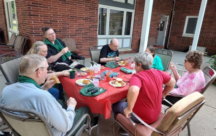 A group of people enjoying a meal together at an outdoor table.