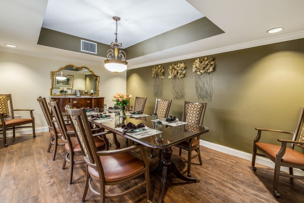 A beautifully decorated dining room with a wooden dining table, chairs, and an elegant chandelier.