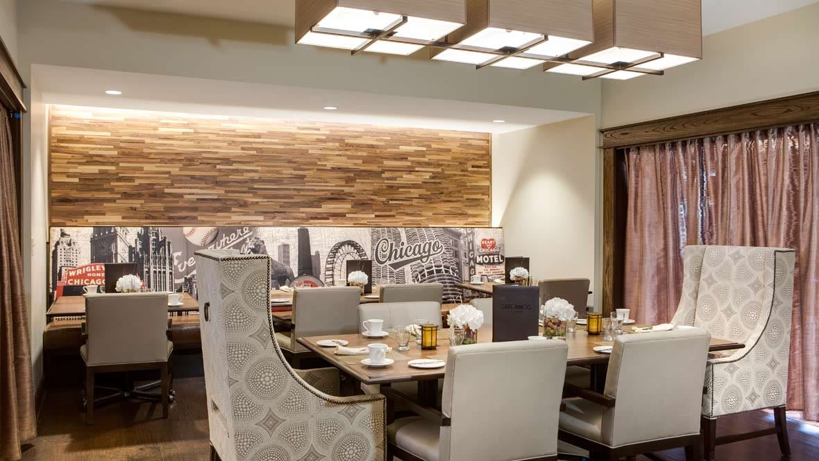 A modern restaurant dining area with a large table, elegant chairs, and stylish lighting.