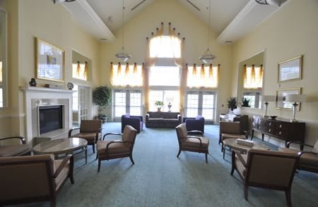A spacious and bright living room with elegant seating and large windows.