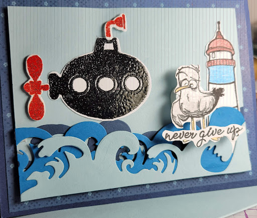 A whimsical handmade card featuring a submarine, a lighthouse, and dynamic waves.