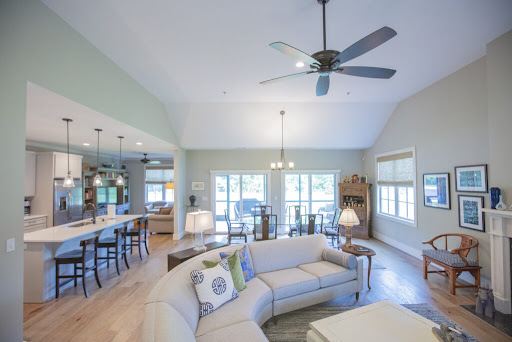 A bright and airy living room featuring an open concept design with a cozy sofa and natural light streaming in.