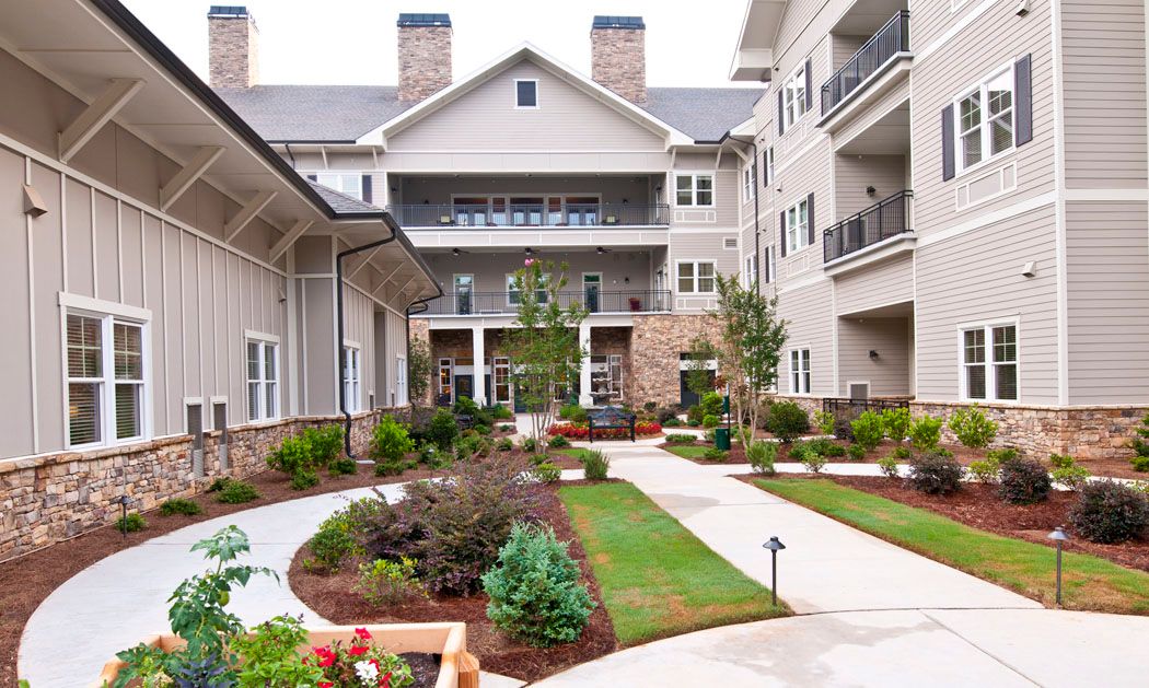 A landscaped courtyard between residential buildings with pathways and greenery.