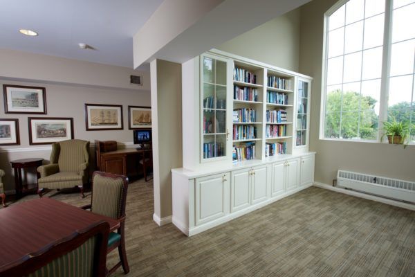 A modern interior featuring a sleek bookshelf and a comfortable reading area.