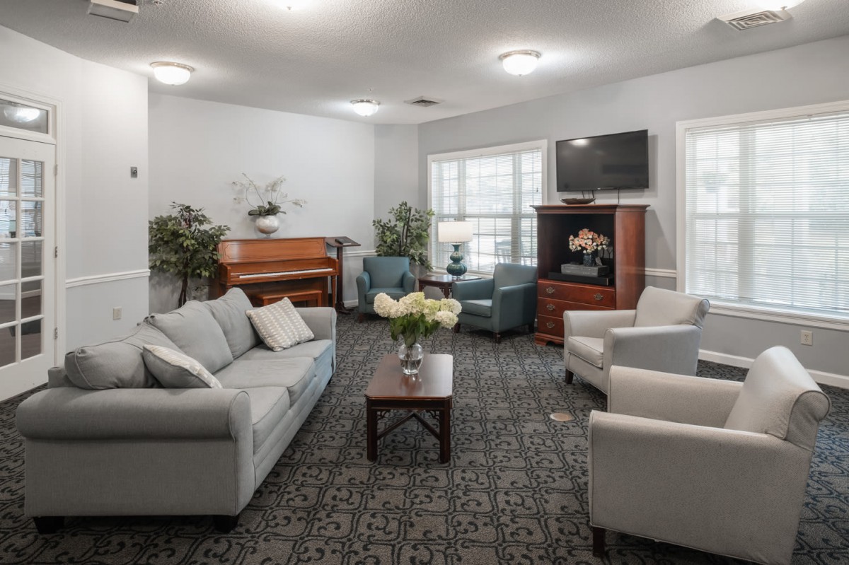 A cozy living room with comfortable seating and a piano.