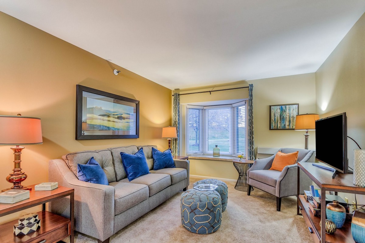A cozy living room with a sofa, armchair, and stylish decor.