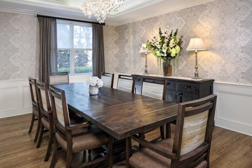 A beautifully decorated dining room with a wooden table, chairs, and a chandelier.