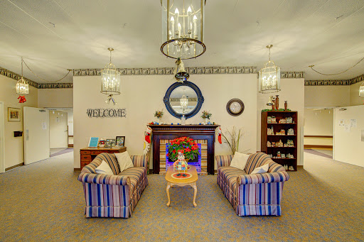 A cozy living room featuring striped sofas, decorative accents, and a warm fireplace.