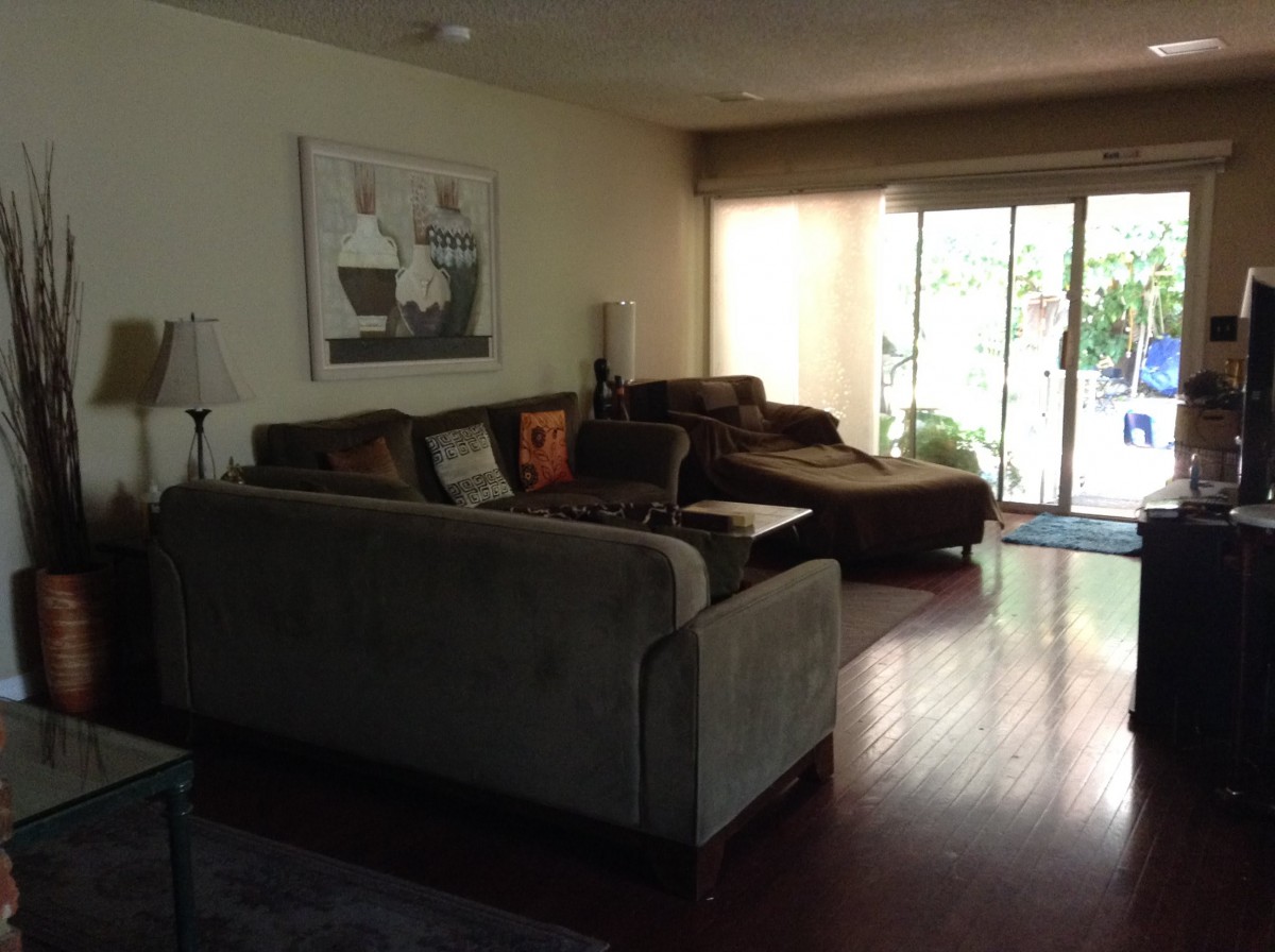 A cozy living room with a large sofa and sliding glass doors.