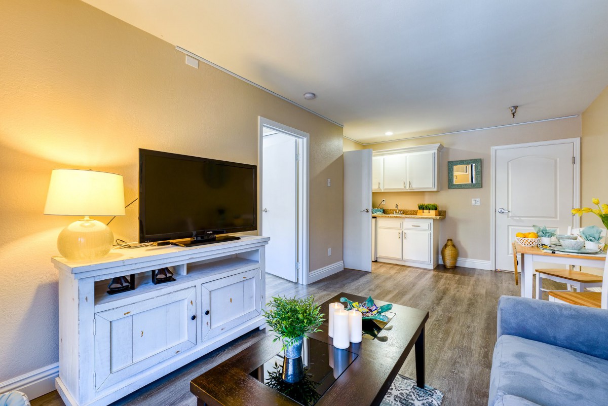 A cozy living room with a TV, coffee table, and modern decor.
