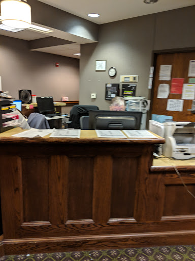 A reception area with wooden counter and computer stations in the background.