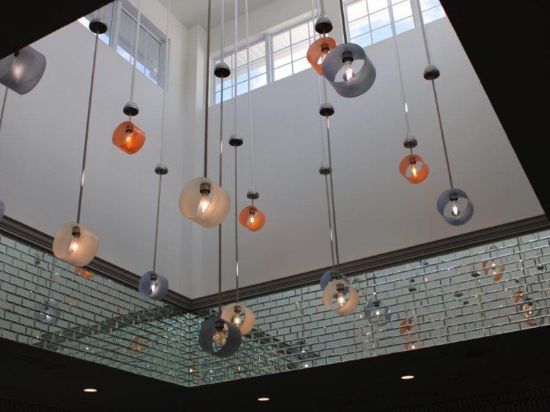 A modern ceiling featuring an array of pendant lights with various colors and sizes, enhancing the contemporary aesthetic of the room.
