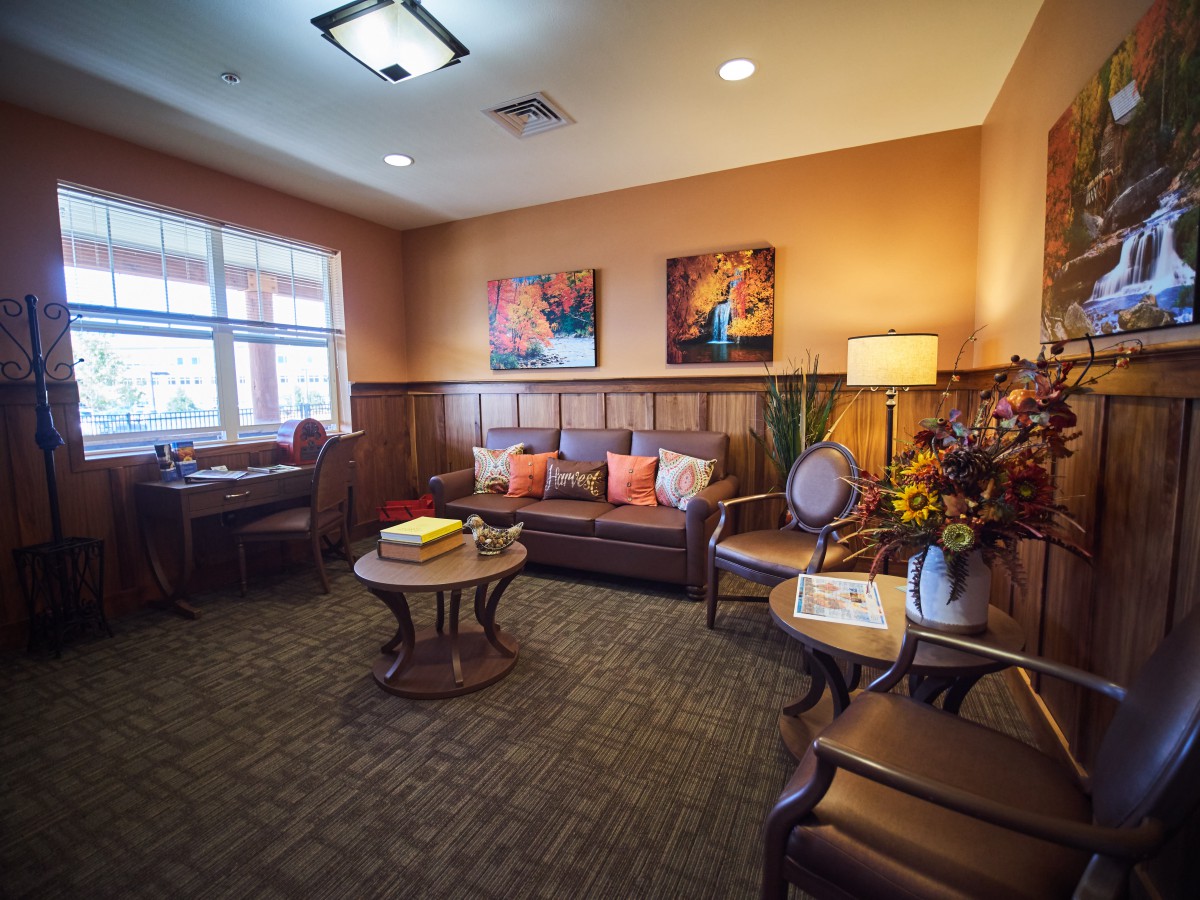 A cozy living room with warm lighting, featuring a comfortable sofa, decorative pillows, and artwork on the walls.