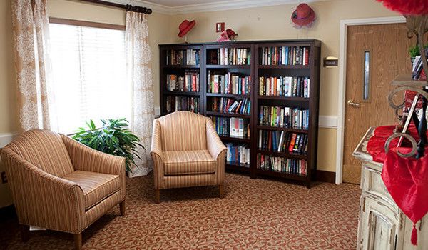 Cozy reading nook with bookshelves filled with books and comfortable armchairs.