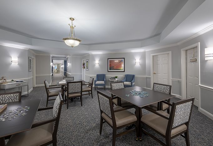 A well-lit meeting room with tables and chairs, decorated with artwork on the walls.