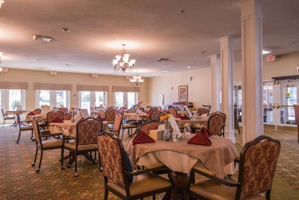 A spacious dining room with neatly arranged tables and chairs, featuring elegant decor.