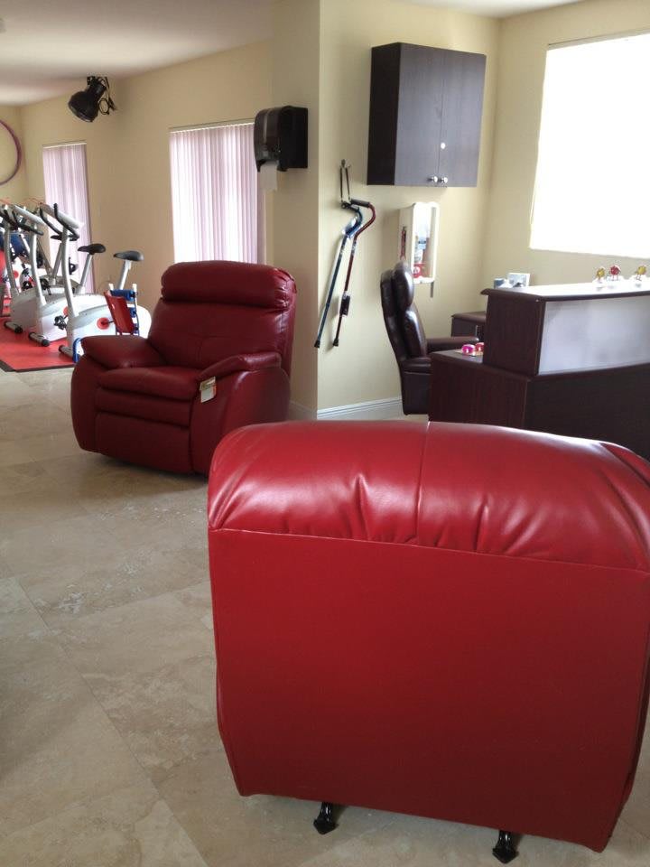 A cozy living area with red recliners and a home gym setup.