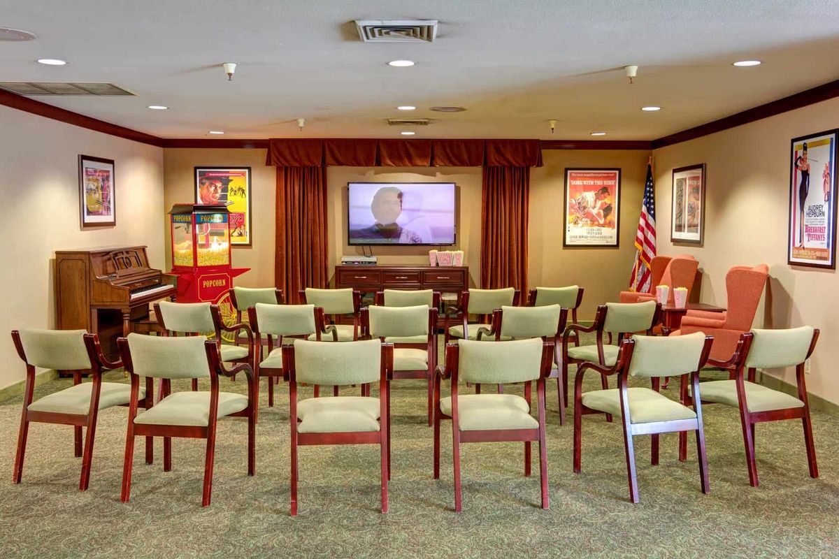 A conference room arranged in a theater style with rows of chairs facing a projector screen.