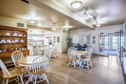 A cozy dining area featuring white wooden furniture and ample lighting.