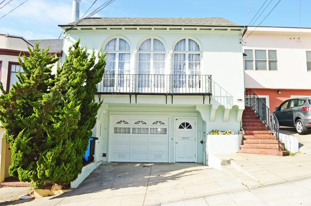 A two-story residential house with a garage and arched windows.