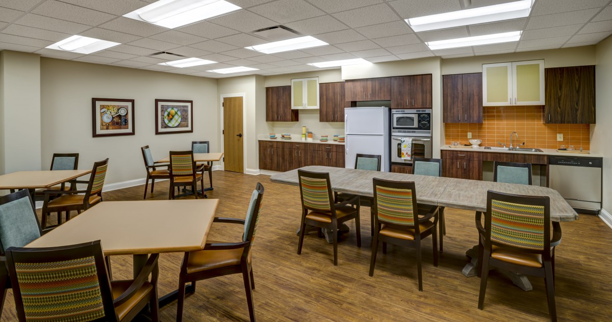 A modern kitchen and dining area with wooden furniture and sleek appliances.