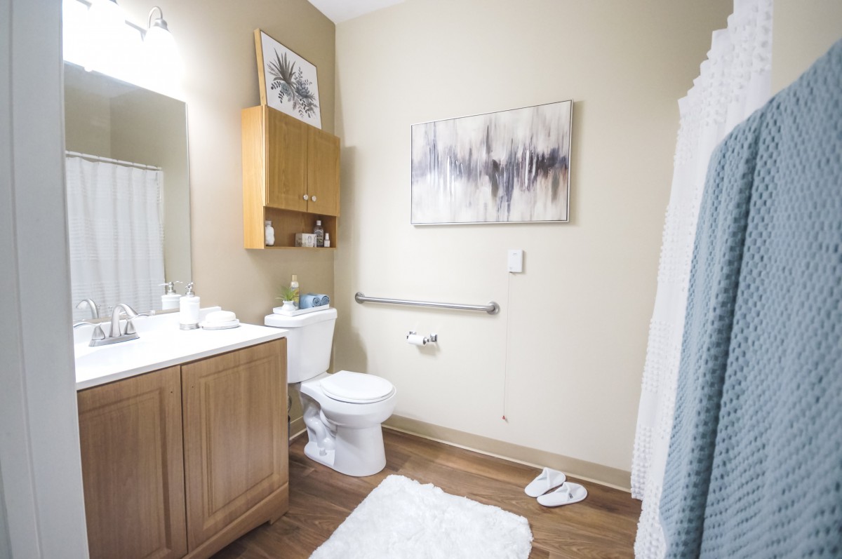 A clean and modern bathroom with artwork on the wall.