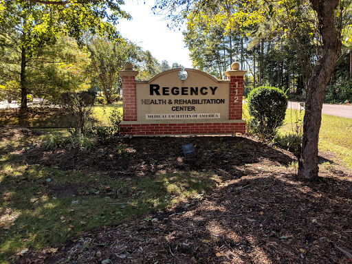 Entrance sign for Regency Health and Rehabilitation Center, surrounded by trees and greenery.