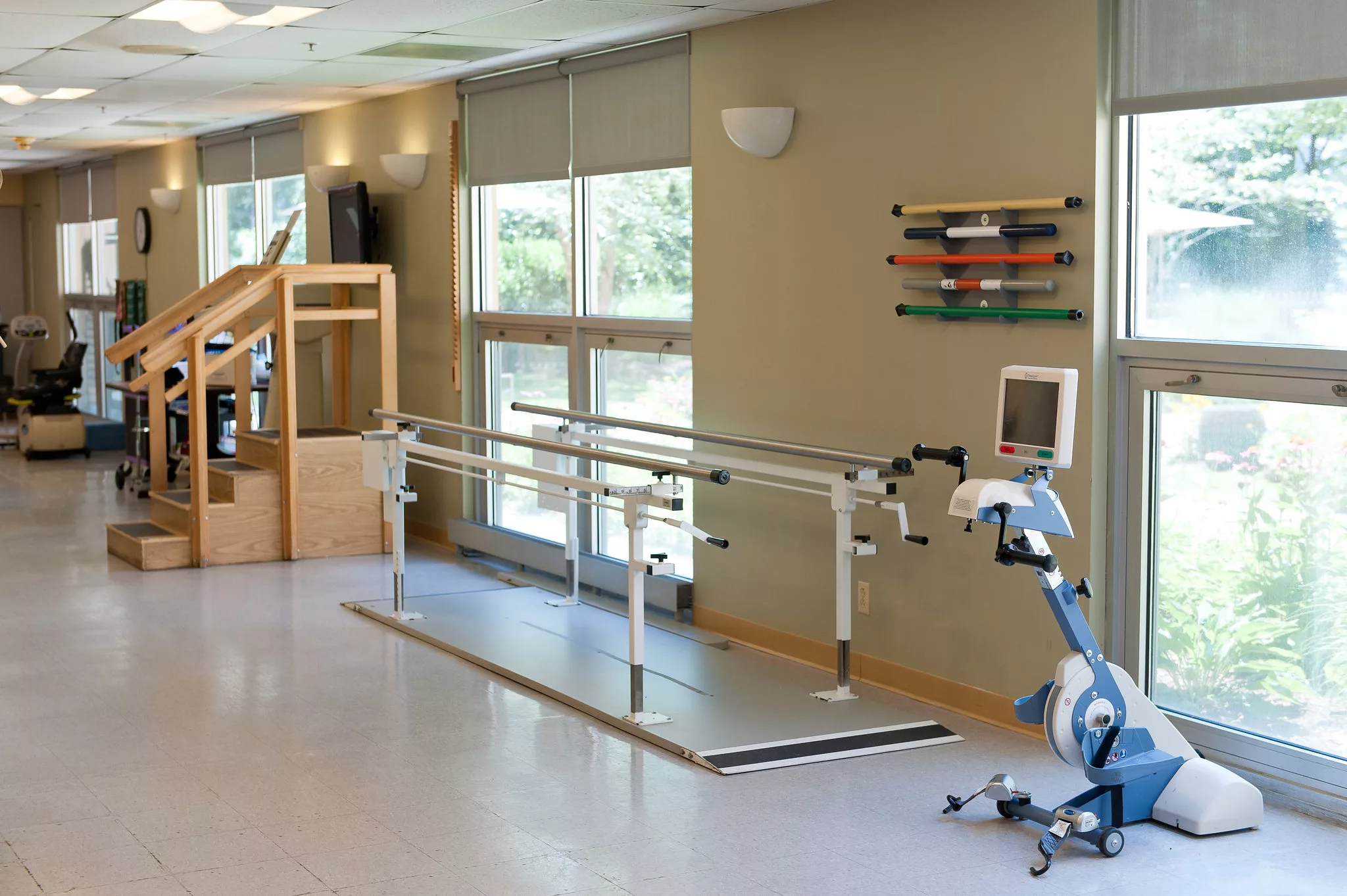 A rehabilitation center featuring parallel bars and exercise equipment for physical therapy.