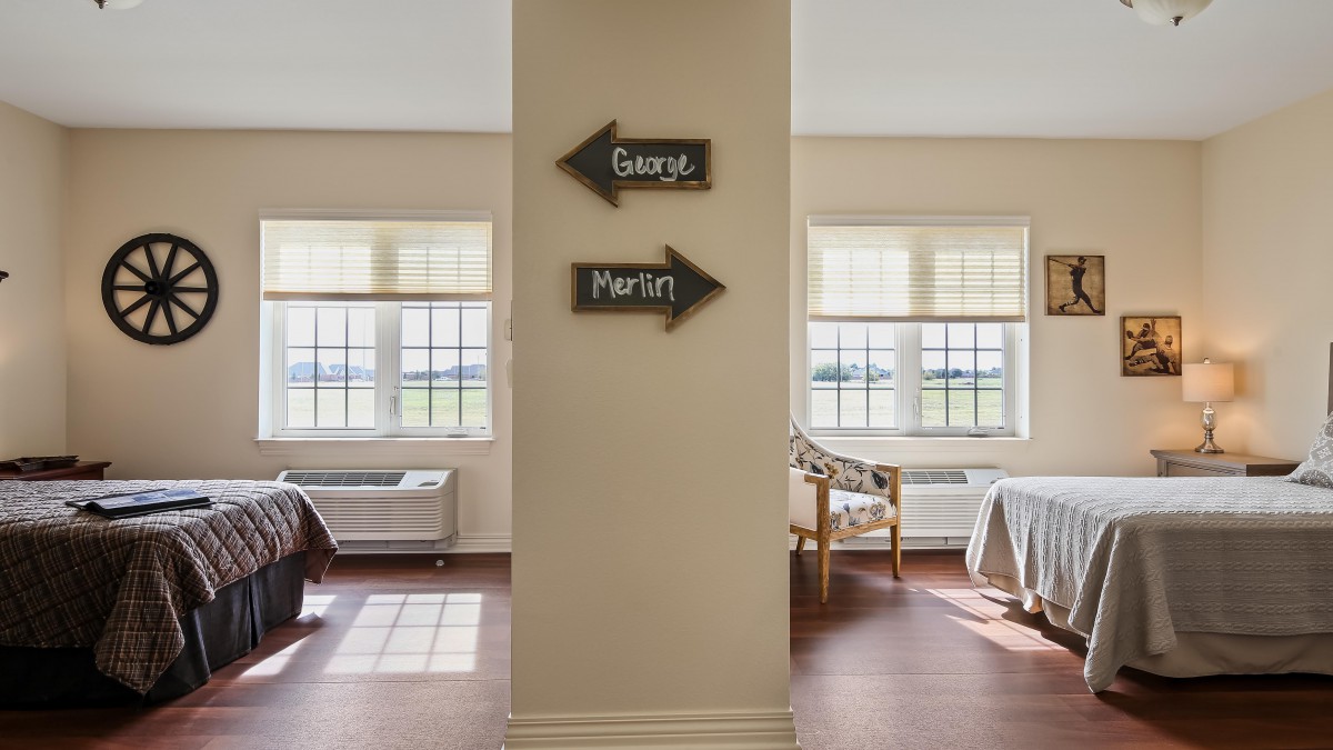 A hospital hallway with directional signs for patient rooms.