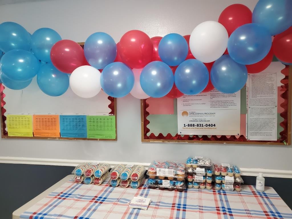 A festive table setting with colorful balloons overhead, ready for a celebration.