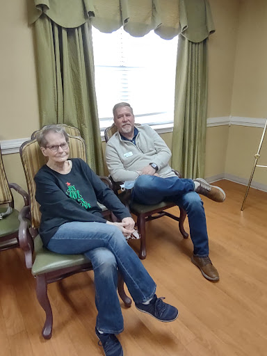 Two individuals seated in a cozy indoor setting, enjoying a casual moment.