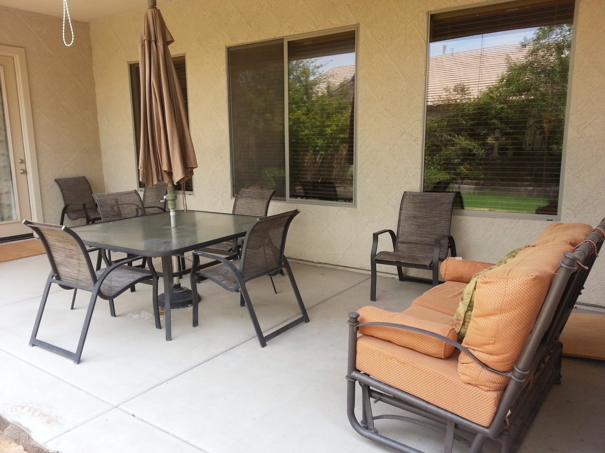 A cozy patio with a dining set and cushioned seating, perfect for outdoor gatherings.