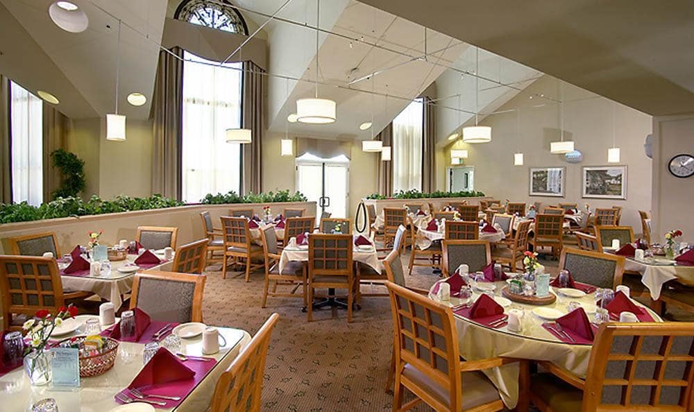 An elegant restaurant dining room with neatly arranged tables and chairs.