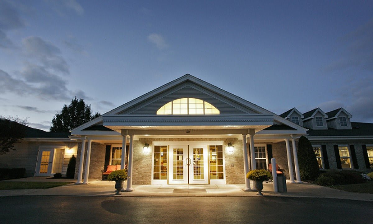 A well-lit building entrance at dusk with symmetrical architectural design.