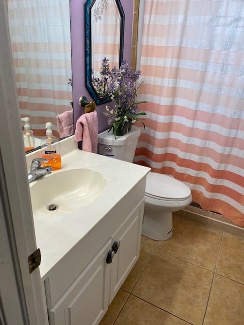 A clean and tidy bathroom with a sink, toilet, and striped shower curtain.